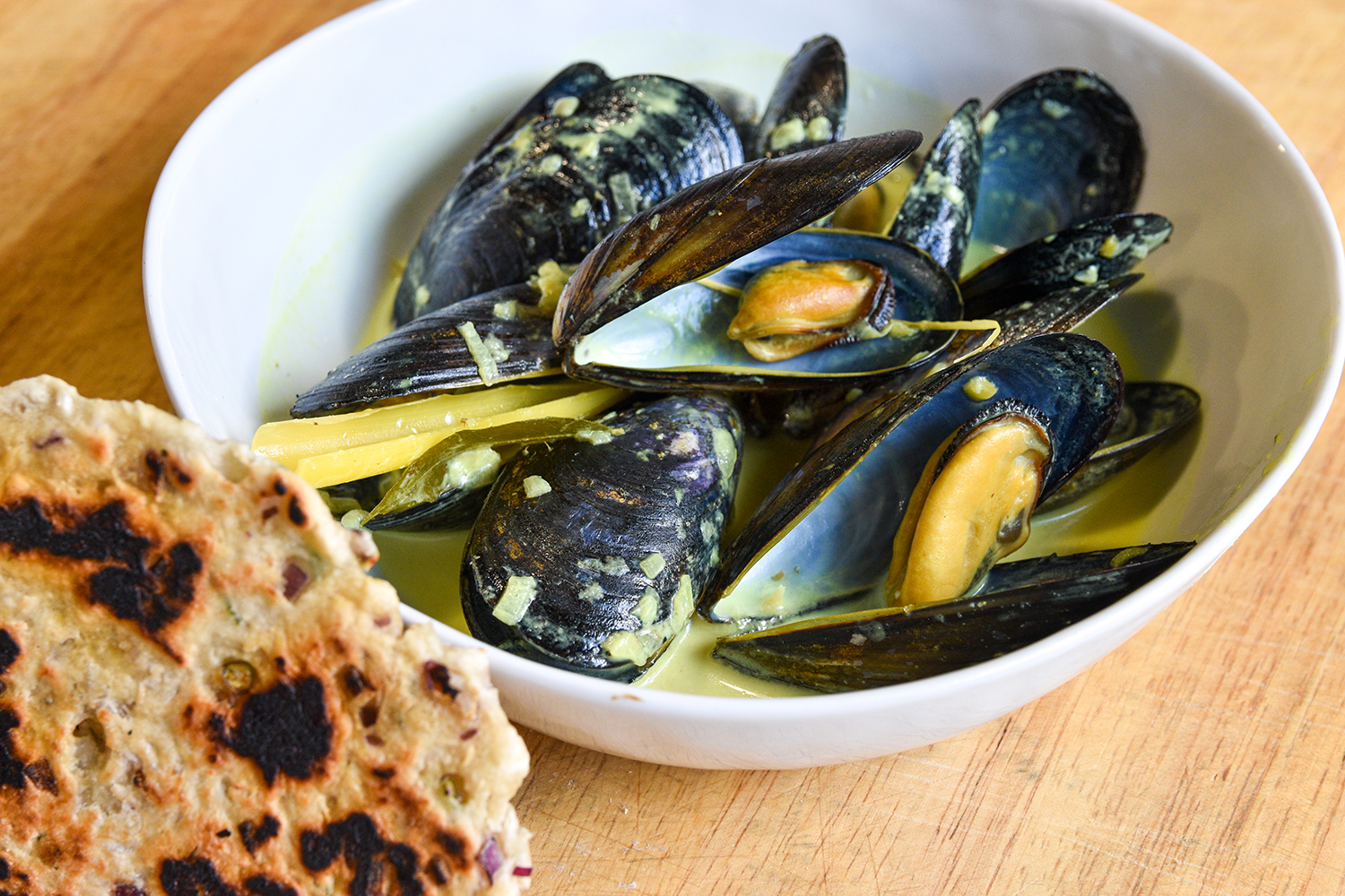 A bowl of Mussel Hodi and a piece of Pol Roti